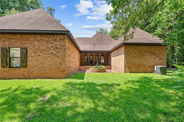 back of property with cooling unit and a lawn