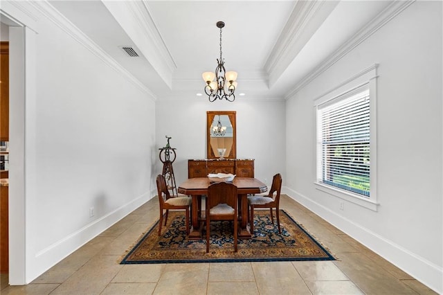 tiled dining room featuring crown molding, a tray ceiling, and a chandelier