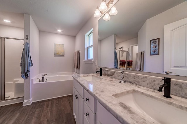bathroom featuring a sink, a bath, wood finished floors, and a shower stall