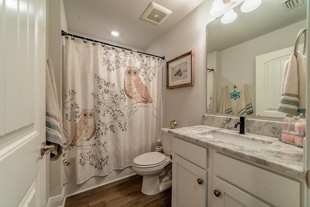 bathroom featuring toilet, visible vents, wood finished floors, and vanity