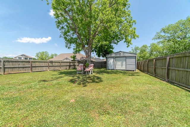 view of yard featuring a fenced backyard, a storage unit, and an outdoor structure