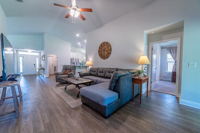 living area featuring baseboards, ceiling fan, dark wood-style flooring, and lofted ceiling