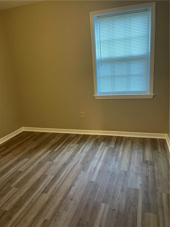 unfurnished room with dark hardwood / wood-style flooring