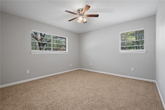 empty room with carpet flooring, ceiling fan, and a healthy amount of sunlight