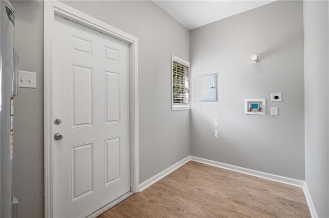 clothes washing area with hookup for an electric dryer, light wood-type flooring, baseboards, laundry area, and electric panel