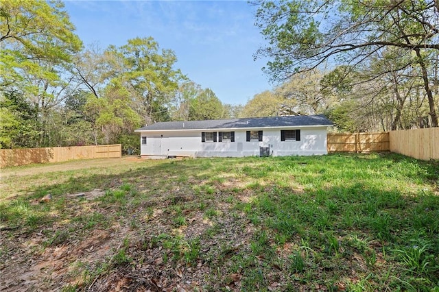 back of house featuring a lawn and fence