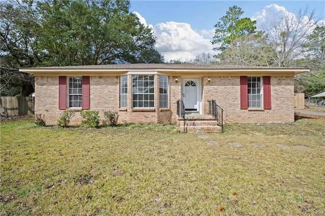 ranch-style house featuring brick siding, a front yard, and fence