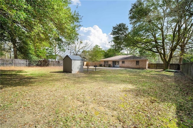 view of yard with an outbuilding, a fenced backyard, a patio area, and a storage unit