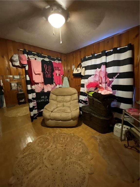 interior space with wooden walls and ceiling fan