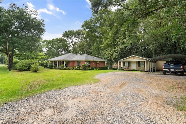 12850 Saeger Rd, Grand Bay, AL 36541 - ranch-style house featuring gravel driveway, a front lawn, and a carport