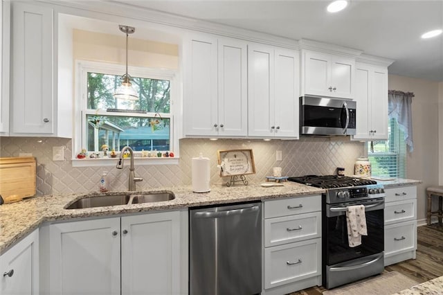 12850 Saeger Rd, Grand Bay, AL 36541 - kitchen featuring appliances with stainless steel finishes, white cabinetry, wood finished floors, light stone counters, and recessed lighting