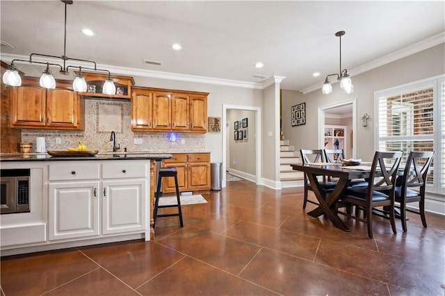 2217 Shandwick Dr, Mobile, AL 36695 - kitchen with backsplash, ornamental molding, baseboards, stainless steel microwave, and dark countertops