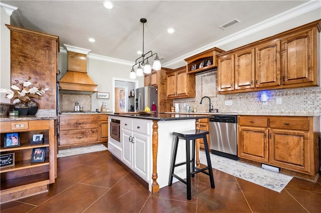2217 Shandwick Dr, Mobile, AL 36695 - kitchen with appliances with stainless steel finishes, crown molding, backsplash, brown cabinets, and recessed lighting