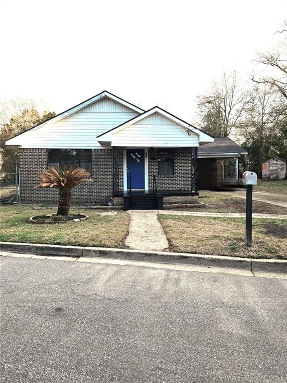 view of front of home featuring a front yard and brick siding