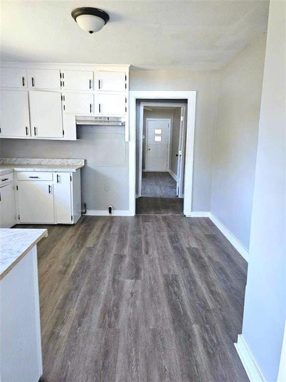 kitchen featuring baseboards, white cabinetry, light countertops, and dark wood-style flooring