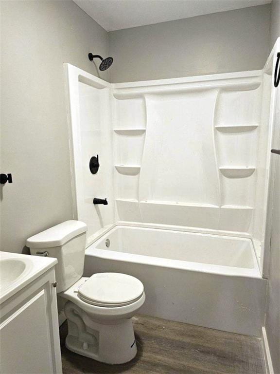 bathroom featuring washtub / shower combination, vanity, wood finished floors, and toilet