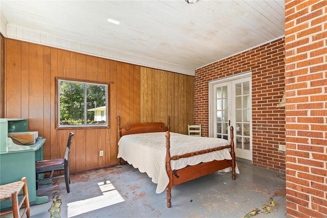 25 Benedict Pl, Mobile, AL 36606 - bedroom with french doors, wood walls, concrete flooring, and brick wall