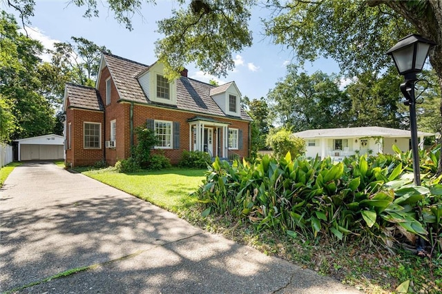 25 Benedict Pl, Mobile, AL 36606 - cape cod home with brick siding, a front yard, and an outbuilding