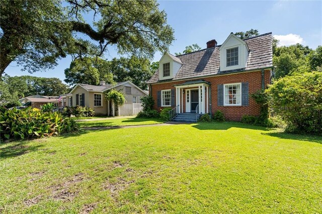 25 Benedict Pl, Mobile, AL 36606 - cape cod home featuring brick siding, a front lawn, and a chimney