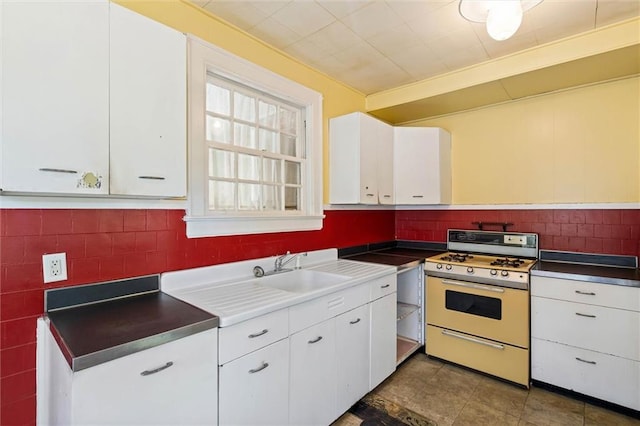 25 Benedict Pl, Mobile, AL 36606 - kitchen featuring gas range gas stove, white cabinets, decorative backsplash, and a sink
