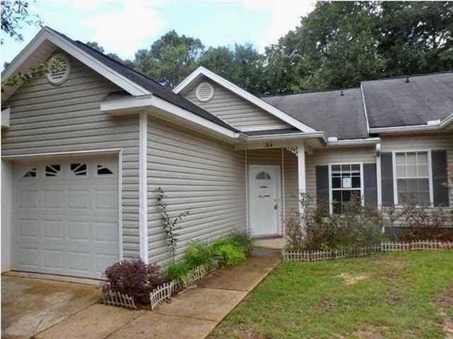 single story home with a garage and a front lawn