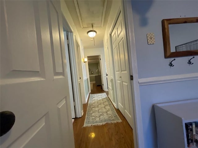 corridor with attic access and dark wood-type flooring
