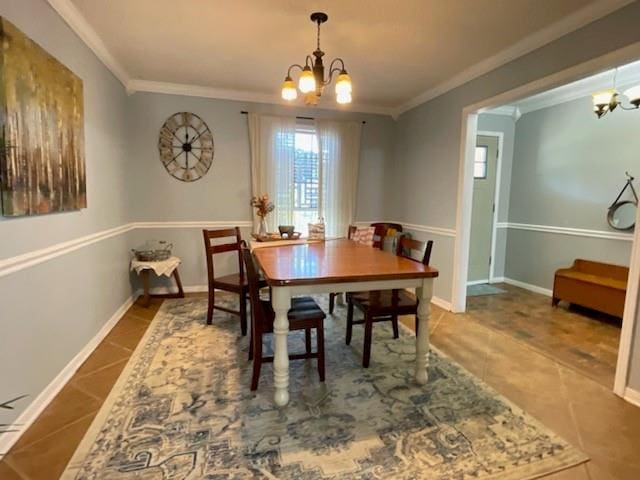 dining room with tile patterned floors, a chandelier, ornamental molding, and baseboards