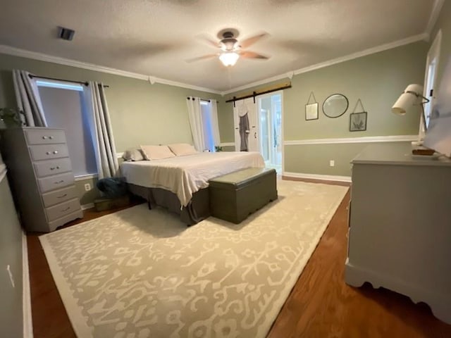 bedroom with baseboards, ornamental molding, and wood finished floors