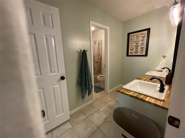 full bath with baseboards, a sink, tile patterned floors, and toilet