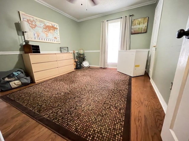 bedroom featuring baseboards, ornamental molding, a ceiling fan, and wood finished floors