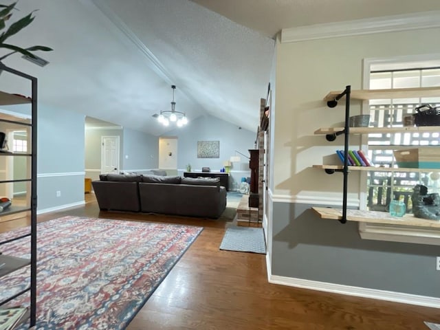 living room featuring crown molding, baseboards, vaulted ceiling, and wood finished floors