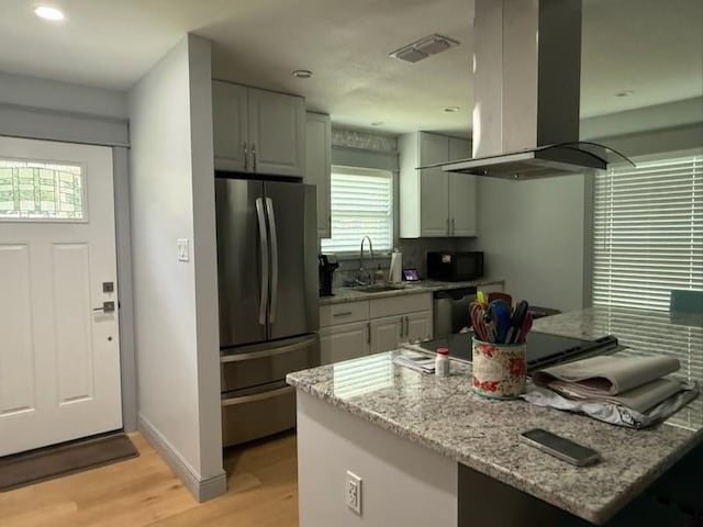 1071 Coke Ct, Mobile, AL 36695 - kitchen with island exhaust hood, appliances with stainless steel finishes, light wood-style floors, light stone counters, and recessed lighting