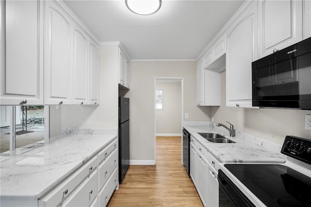 kitchen featuring black appliances, light stone counters, white cabinetry, sink, and light hardwood / wood-style flooring