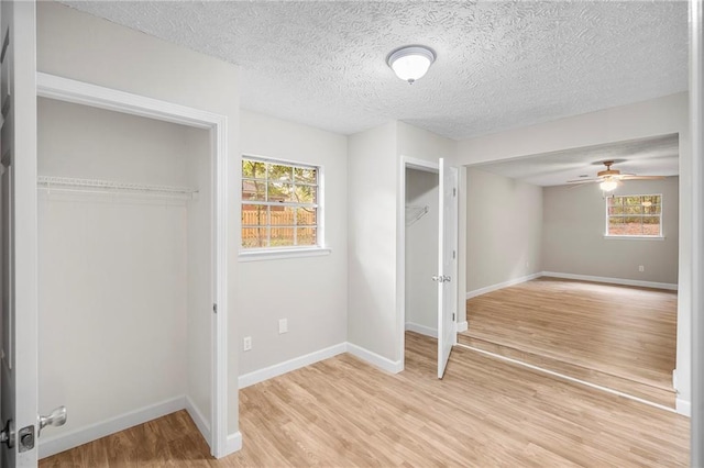 interior space featuring a textured ceiling, a wealth of natural light, and light hardwood / wood-style floors