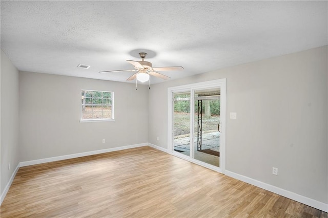 unfurnished room with ceiling fan, a textured ceiling, and light wood-type flooring