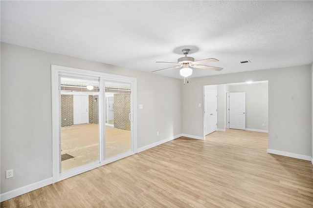 spare room with light hardwood / wood-style floors, ceiling fan, and a textured ceiling