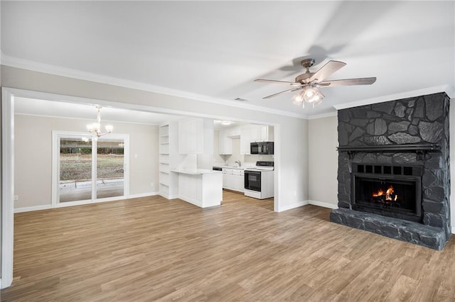 unfurnished living room featuring a fireplace, light hardwood / wood-style flooring, crown molding, and ceiling fan with notable chandelier