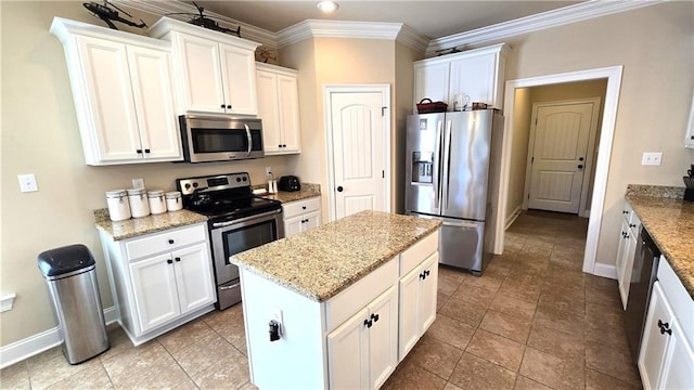 1109 Orlando Dr, Foley, AL 36535 - kitchen with stainless steel appliances, baseboards, a kitchen island, white cabinets, and ornamental molding