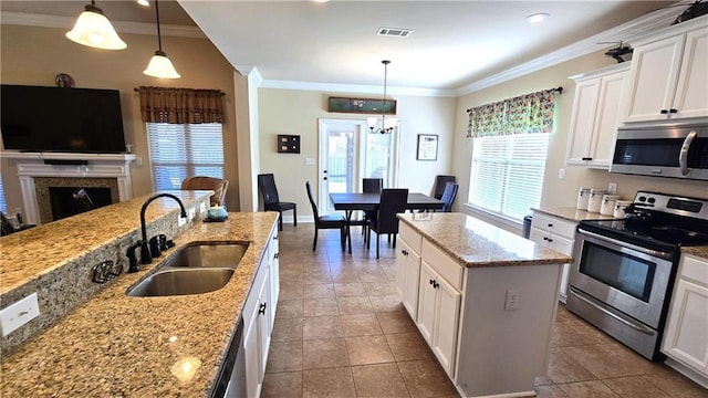 1109 Orlando Dr, Foley, AL 36535 - kitchen with appliances with stainless steel finishes, a sink, crown molding, white cabinetry, and light stone counters