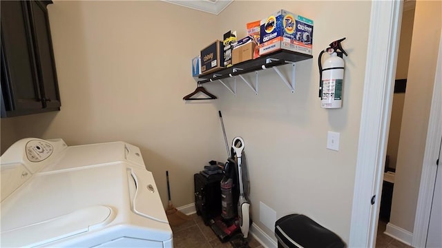 1109 Orlando Dr, Foley, AL 36535 - laundry area featuring cabinet space, washing machine and clothes dryer, dark tile patterned flooring, and baseboards