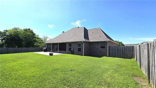 1109 Orlando Dr, Foley, AL 36535 - back of property featuring a sunroom, a patio area, brick siding, and a shingled roof