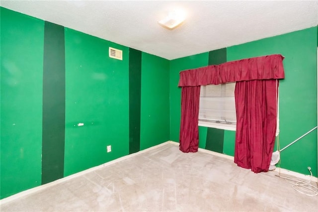 carpeted spare room with a textured ceiling