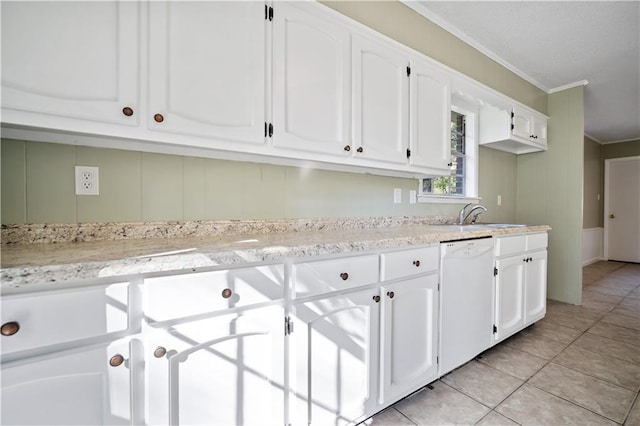 kitchen featuring sink, light tile patterned floors, white cabinets, and dishwasher