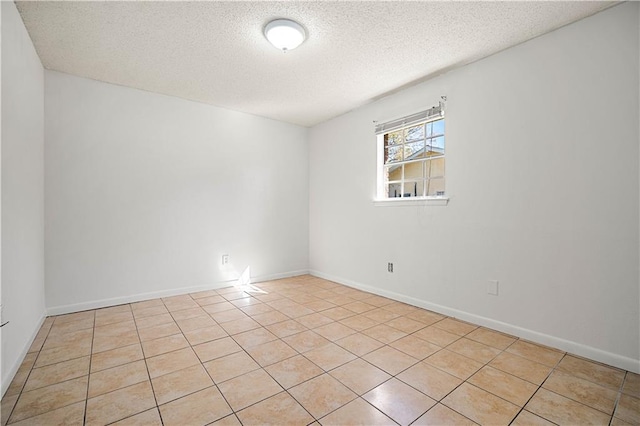 tiled spare room with a textured ceiling