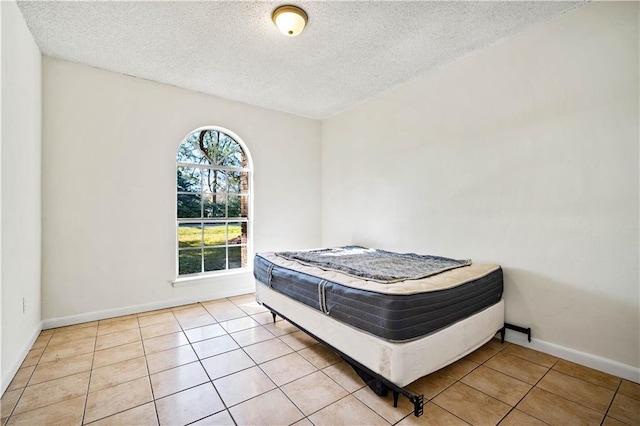 tiled bedroom featuring a textured ceiling