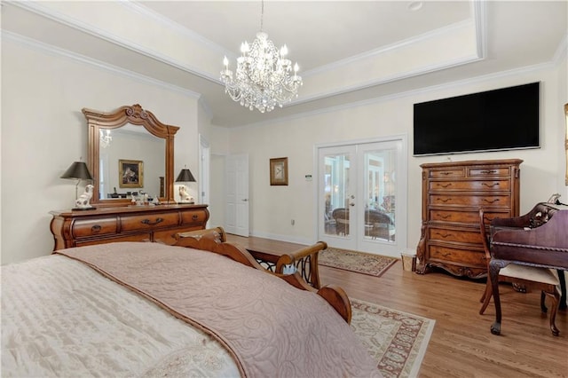 bedroom featuring french doors, a raised ceiling, wood finished floors, and ornamental molding