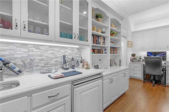 kitchen featuring open shelves, white cabinetry, light wood finished floors, glass insert cabinets, and light countertops