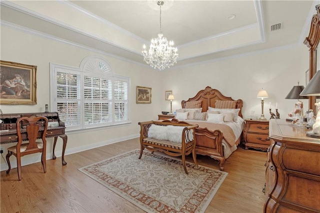 bedroom featuring a chandelier, visible vents, light wood-type flooring, and a tray ceiling