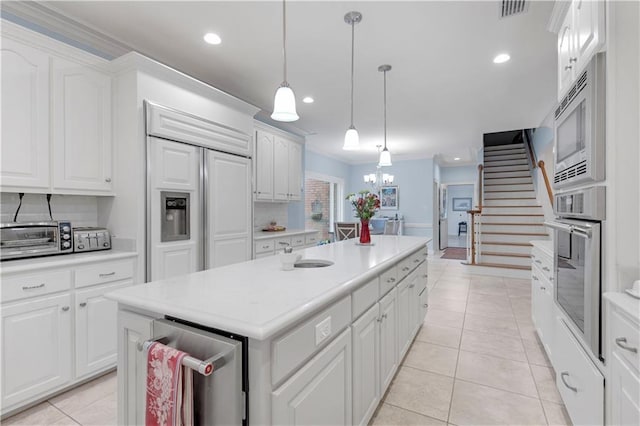 kitchen with white cabinets, light tile patterned flooring, visible vents, and built in appliances