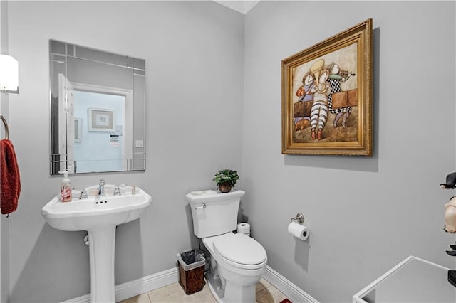 half bathroom with tile patterned floors, baseboards, and toilet